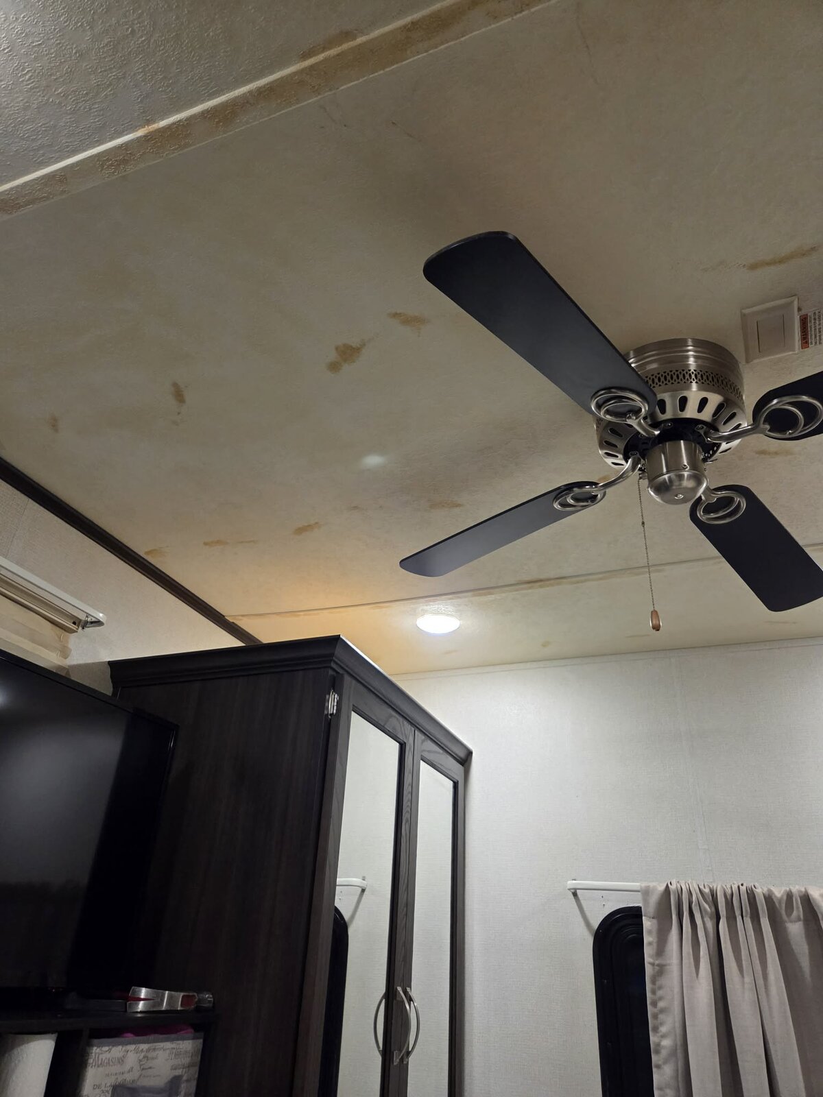 Bedroom ceiling before repaint, water stains and discoloration