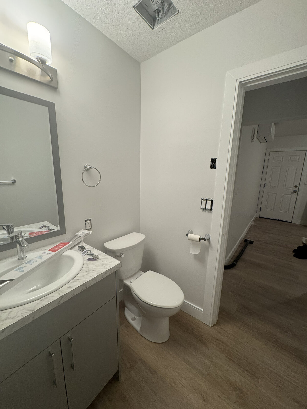Bathroom before paint, raw drywall and exposed electrical